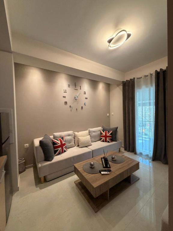a living room with a couch and a clock on the wall at Aggelos Room 1 in Volos