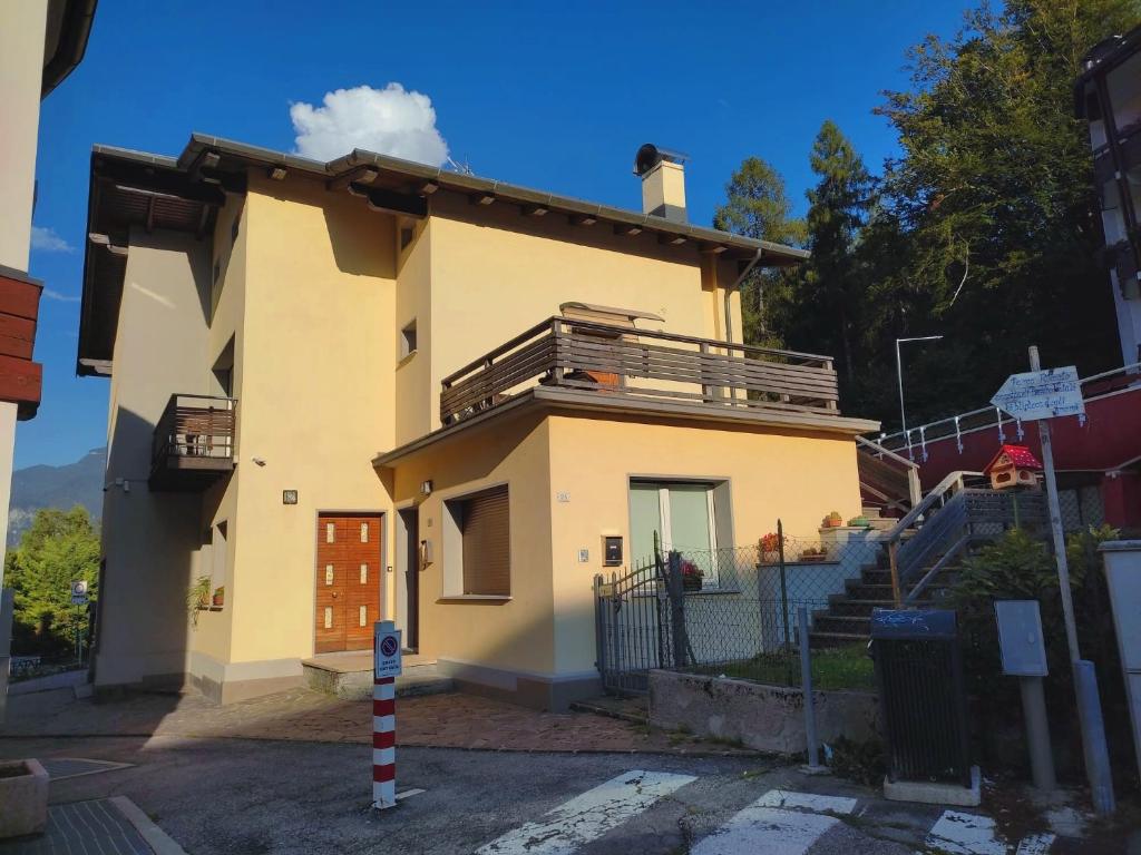 a yellow house with a balcony on top of it at La Casetta Gialla in Pieve di Cadore
