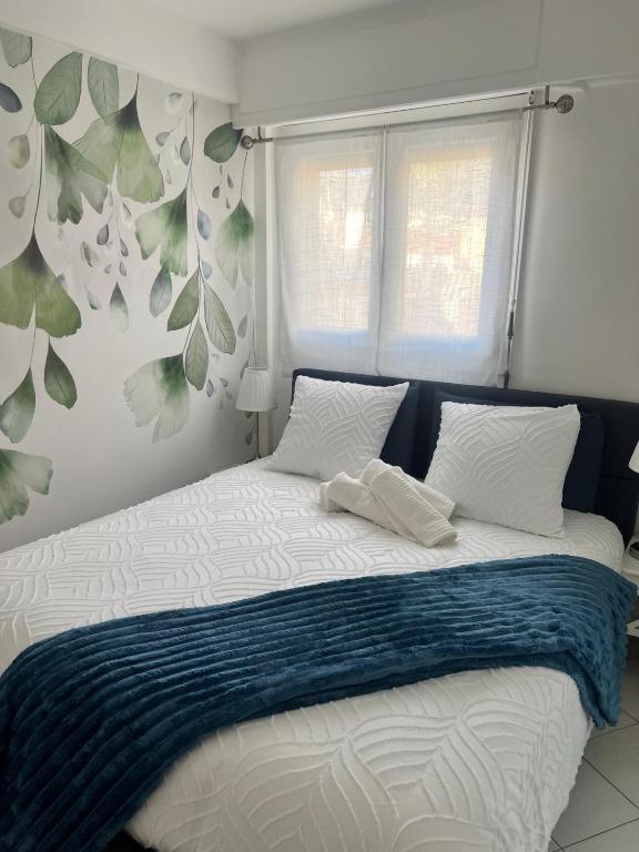 a bed with a blue and white blanket and a window at Gamiga in Menton