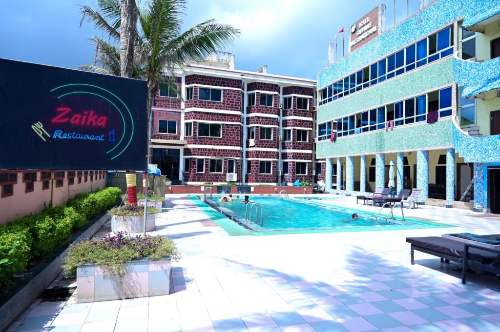 a swimming pool in front of a building at Hotel Sapphire International in Puri