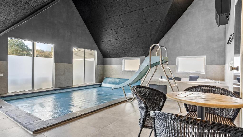 a swimming pool with a slide and a table and chairs at Villavilla 182 - Rømø, Sydjylland in Høm