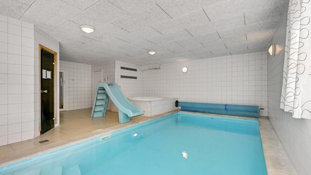 a swimming pool in a bathroom with a slide at Villavilla 247 - Ebeltoft, Østjylland in Ebeltoft