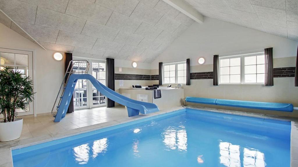 a indoor swimming pool with a slide in a house at Villavilla 386 - Ebeltoft, Østjylland in Ebeltoft