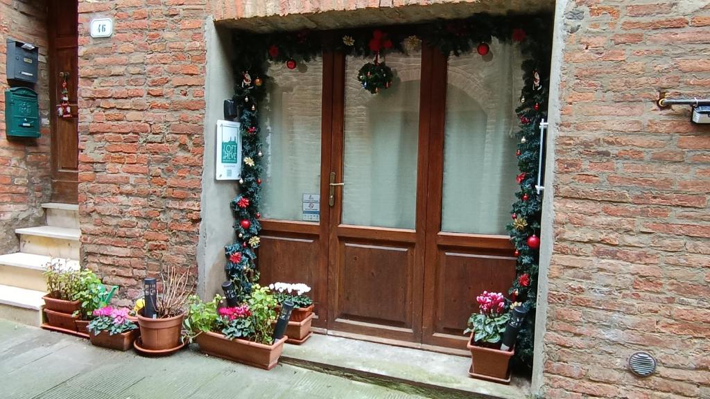 a door with christmas decorations and potted plants in front of a building at Il Loft di Pieve in Città della Pieve
