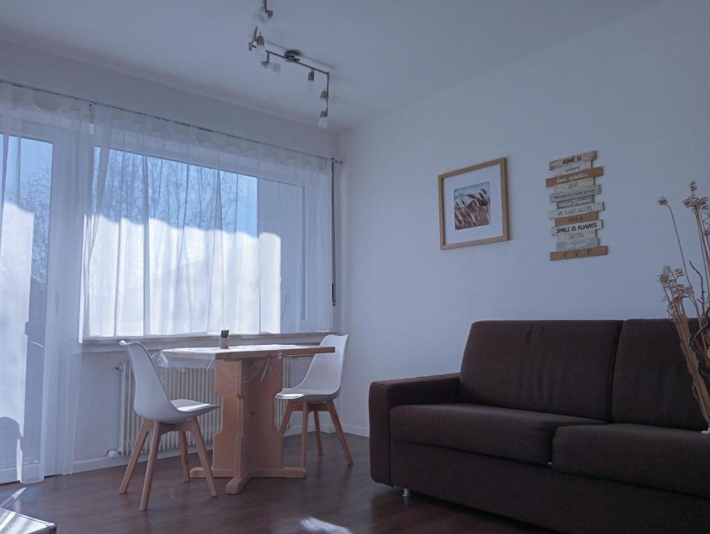 a living room with a couch and a table and chairs at Appartement Margarethen in Vipiteno