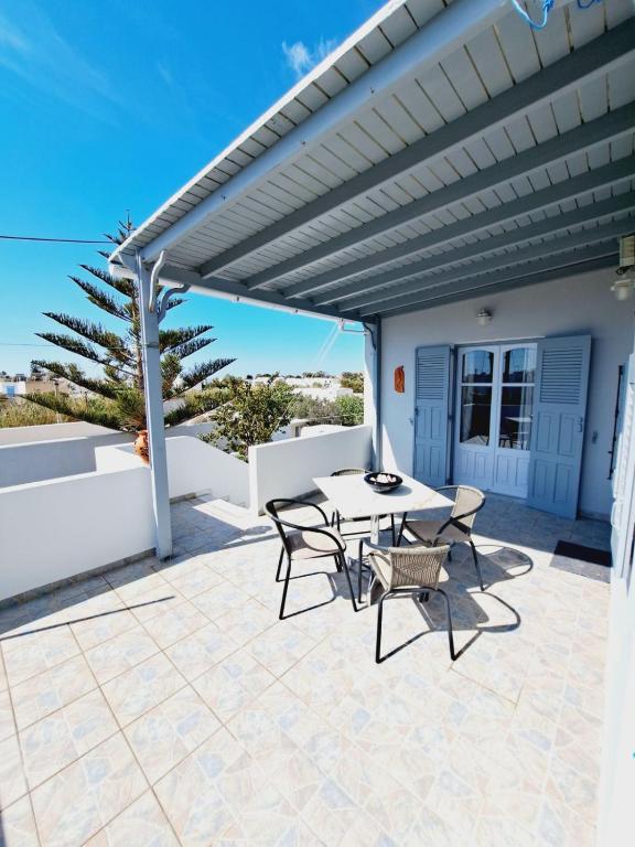 a patio with a table and chairs under a pergola at Κυκλαδίτικο σπίτι με θέα Villa Mimika in Perissa