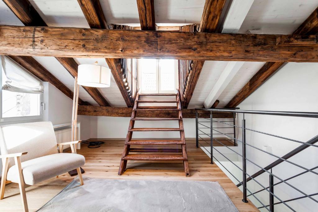 Zimmer mit einer Leiter und einem Stuhl in der Unterkunft Stay COOPER l Laubenhaus in Bozen