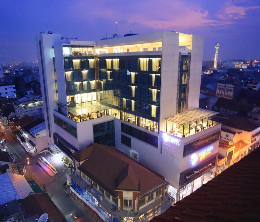 un grand bâtiment éclairé la nuit dans une ville dans l'établissement Pasar Baru Square Hotel Bandung, à Bandung