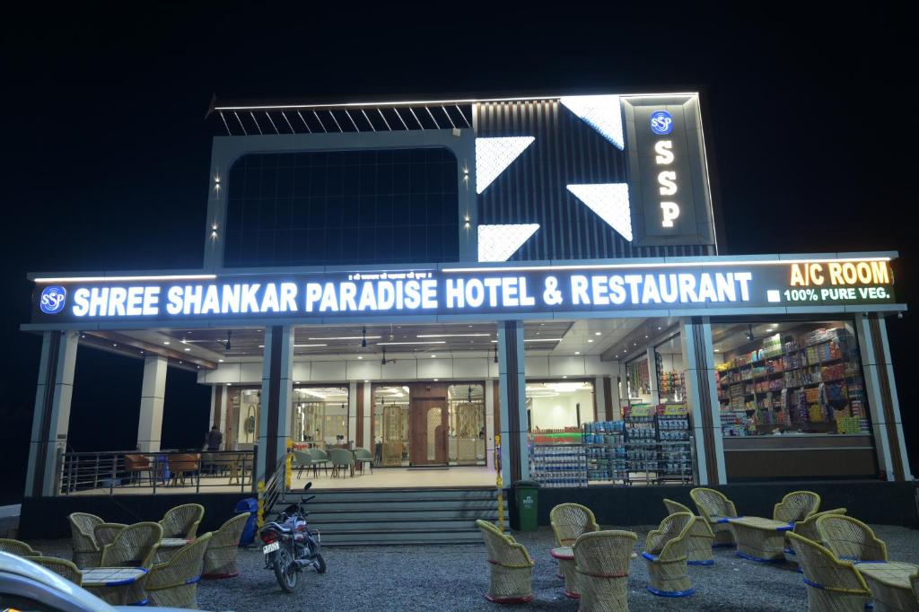 a motorcycle parked in front of a store at night at Shree Shankar Paradise in Pharod