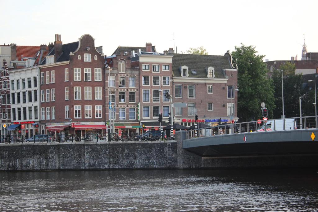 アムステルダムにあるホテル レストラント オールド ブリッジの建物のある都市の川橋