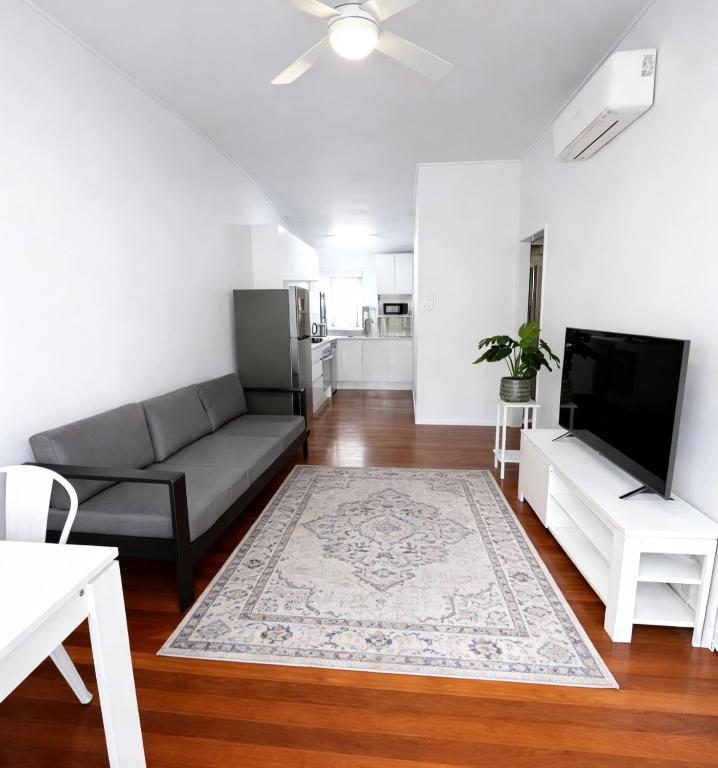a living room with a couch and a flat screen tv at 2bedrm unit next to southbank in Brisbane