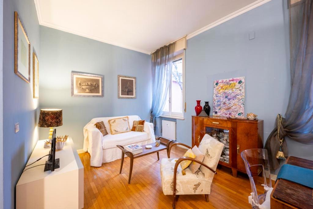 a living room with a white couch and a fireplace at Appartamento San Giovanni - centro storico di Parma in Parma
