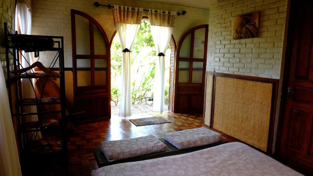 a bedroom with a bed and an open door at Eco Lodge Les Chambres Du Voyageur in Antsirabe
