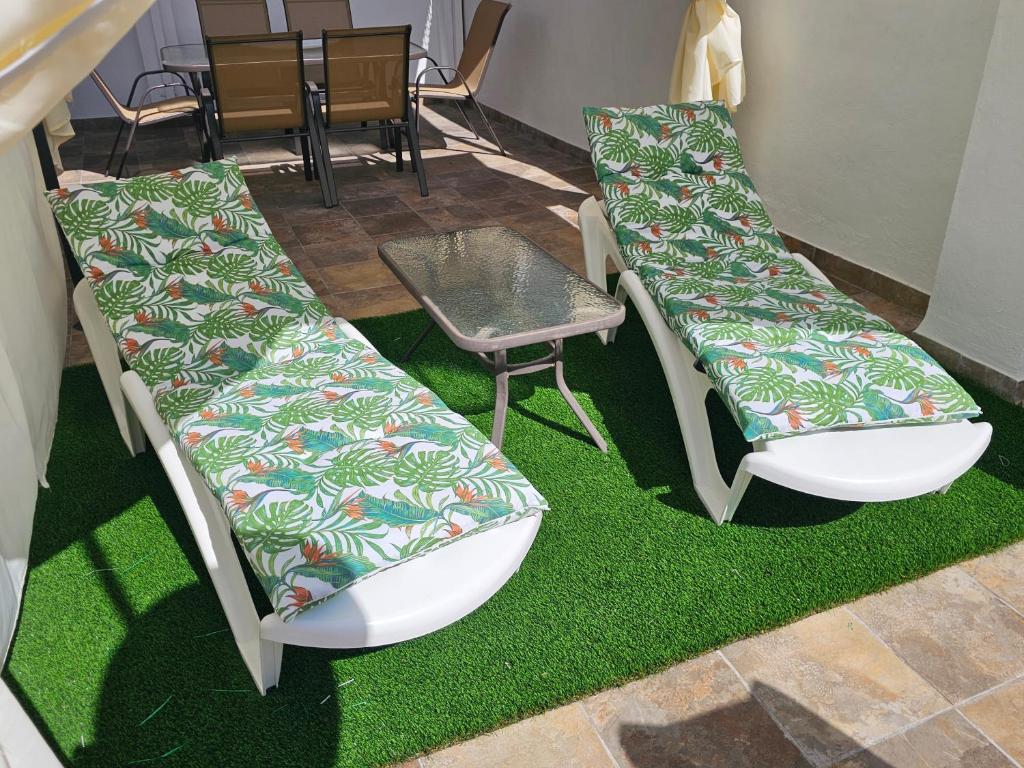 two chairs and a table on some grass at CitySun in Málaga
