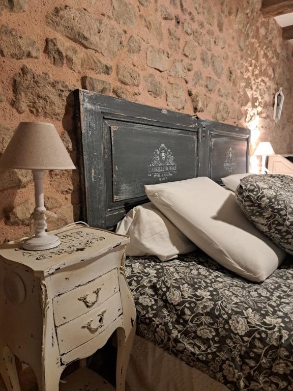a bedroom with a bed and a table with a lamp at maison la Bambine chambre esprit château in Ozolles