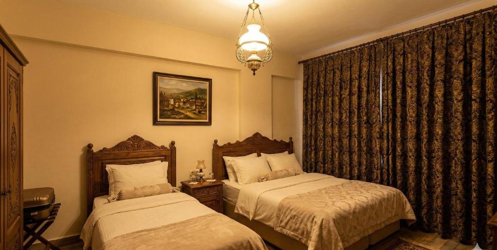 a bedroom with two beds and a chandelier at Zefir Apart in Ordu