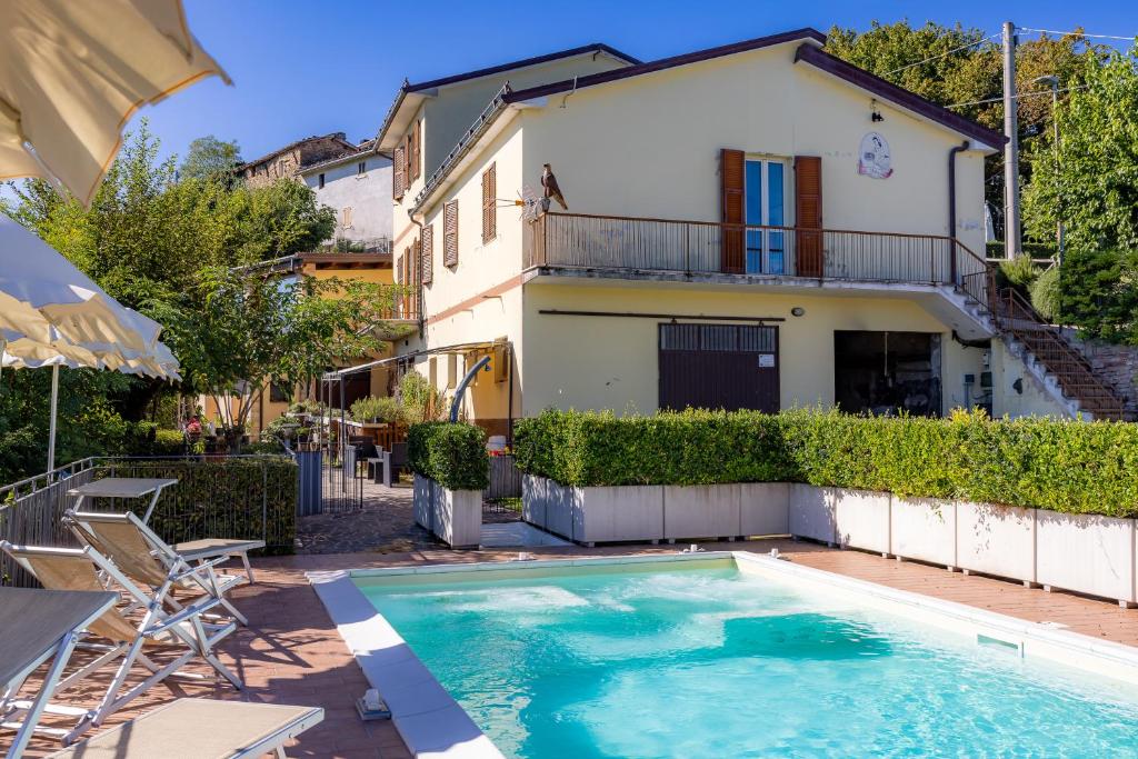 a villa with a swimming pool in front of a house at Casa Priora vista Sibillini in Montefortino