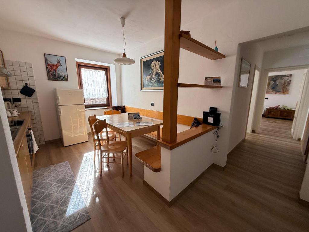 a kitchen and dining room with a table and chairs at Appartamento Moena in Moena