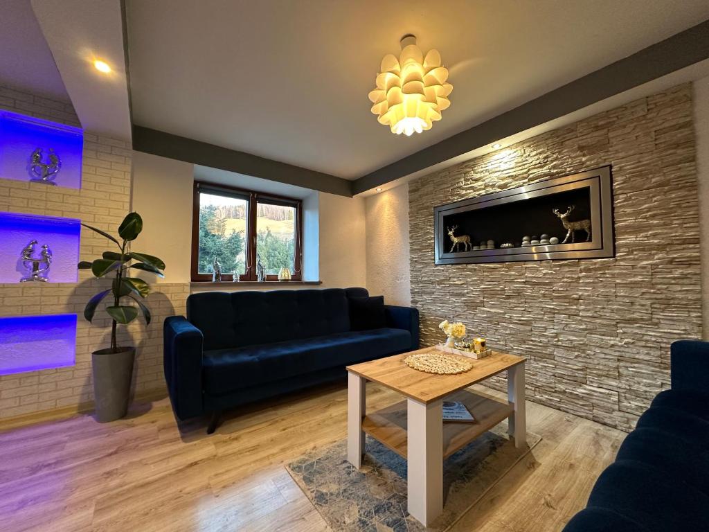 a living room with a couch and a table at Domek Pluto Konradów 1 in Lądek-Zdrój