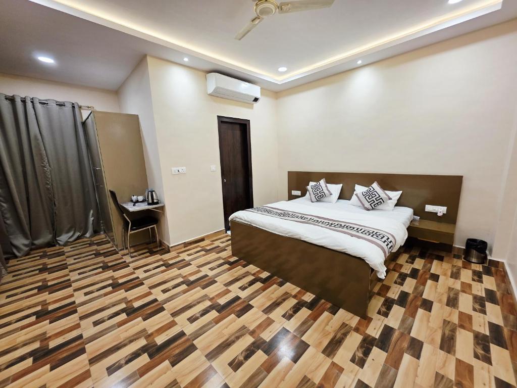 a bedroom with a bed and a wooden floor at Crestview Inn in Lucknow