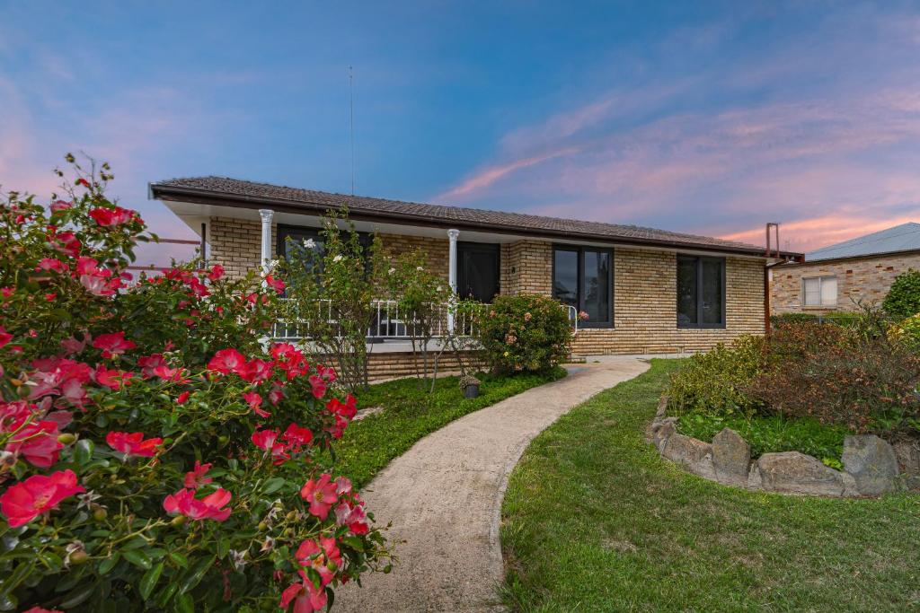 a house with a pathway leading to a yard with flowers at Villa Oberon in Oberon