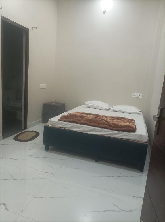 a bedroom with a bed with a blanket on it at आदिनाथ गेस्ट हाउस in Ujjain