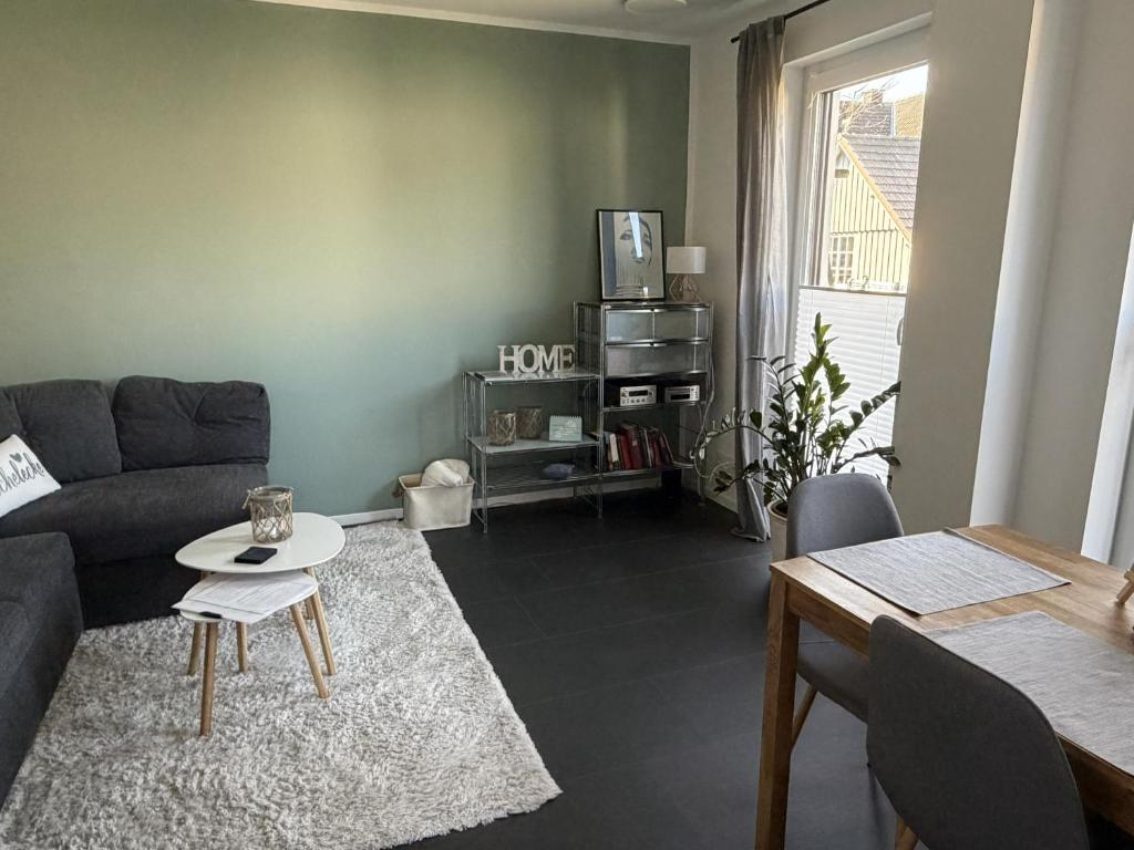 a living room with a couch and a table at Moderne Ferienwohnung über 2 Etagen in Bissendorf