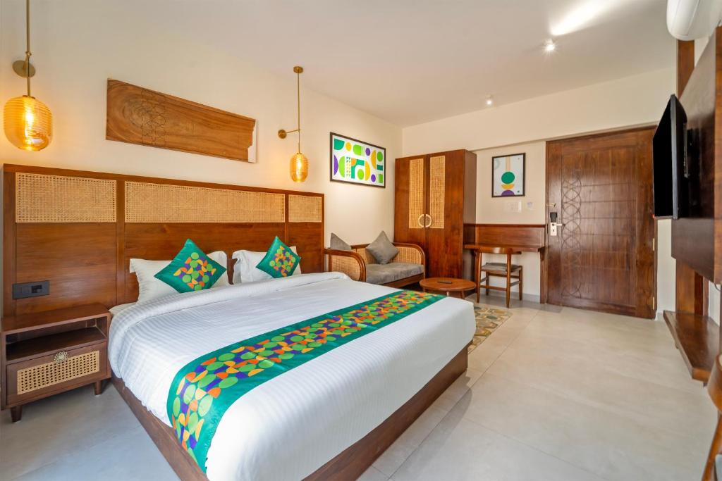 a bedroom with a large bed and a living room at Treebo Premium Cachet Suites in Coimbatore