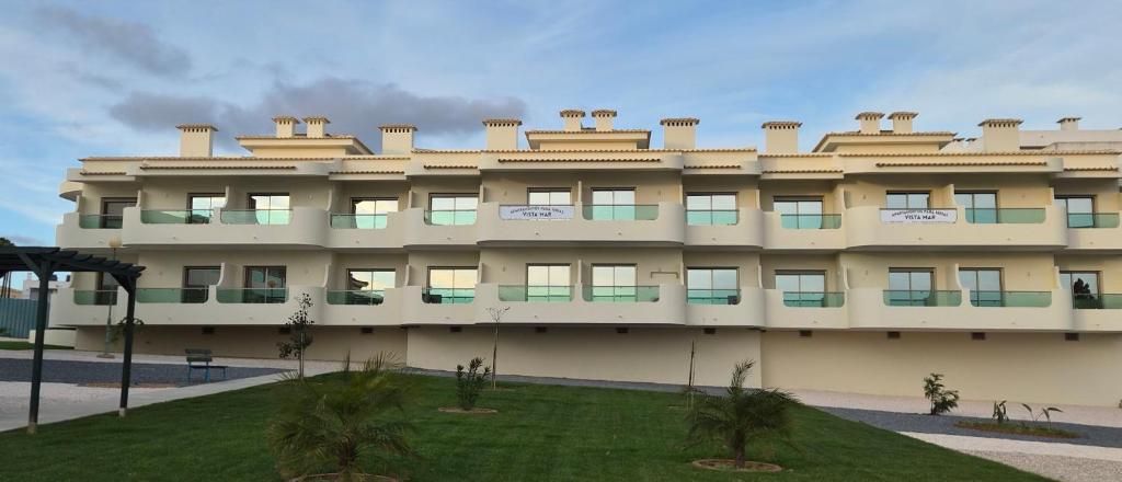 a large building with a lawn in front of it at Apartamentos Vista Mar in Armação de Pêra