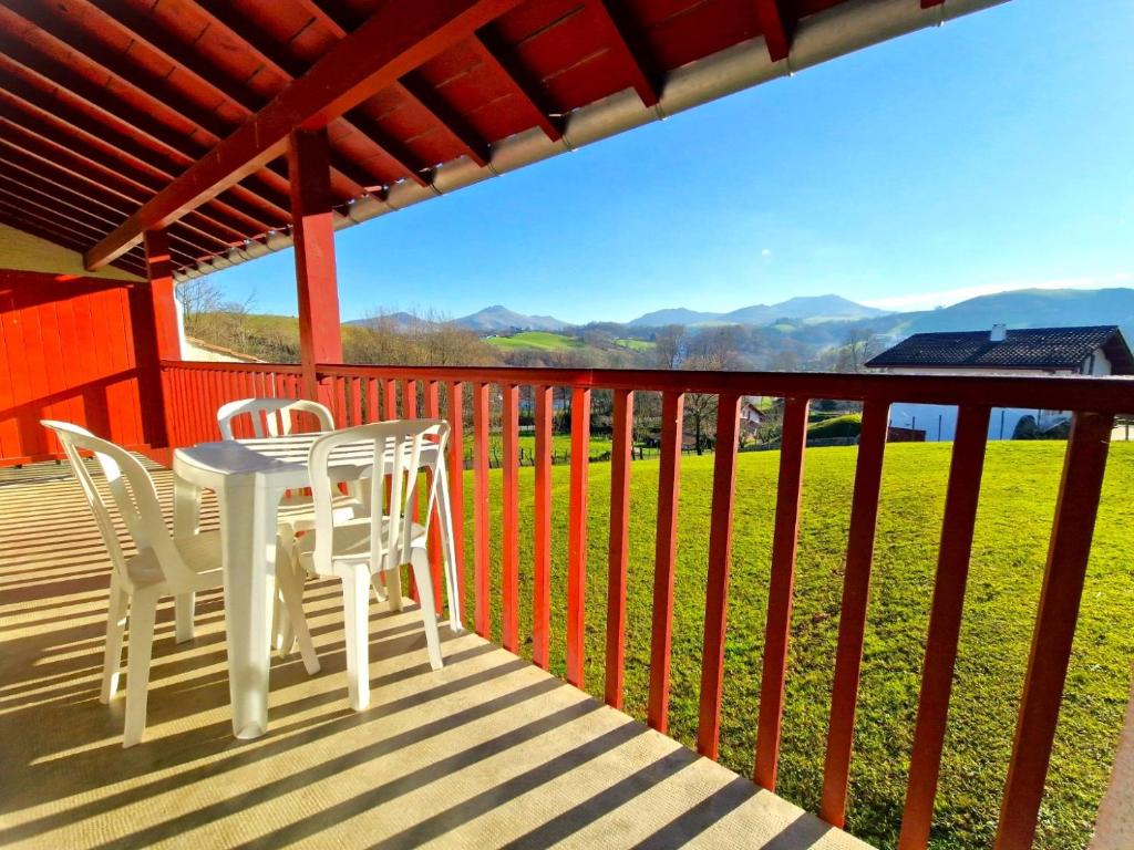 a table and chairs on a deck with a view at B4 Vue Montagnes Piscine in Souraïde