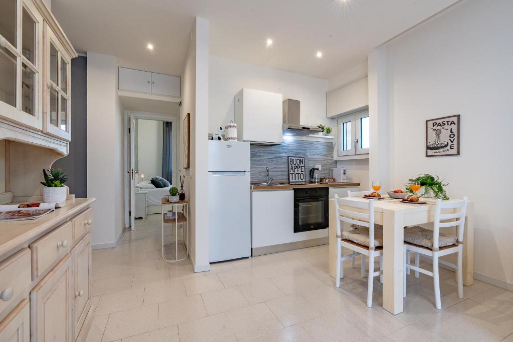 a kitchen with a white refrigerator and a table at Maison di Andrea in Zibido San Giacomo
