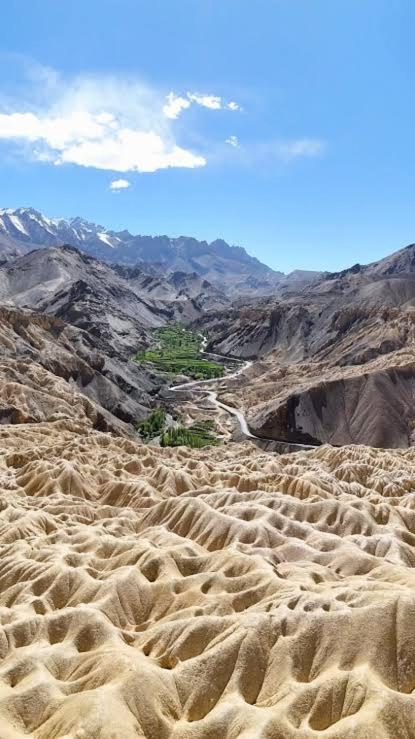 a view of a desert with a road in the distance at ཨོཾ Homestay in Lāmayūrū