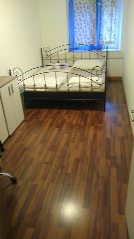 a bedroom with a bed and a wooden floor at Ela Gar 2 WG Zimmer in Garsten