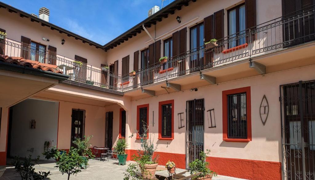 a courtyard of a building with red doors and balconies at Corte Meneghina-short stays in Buscate