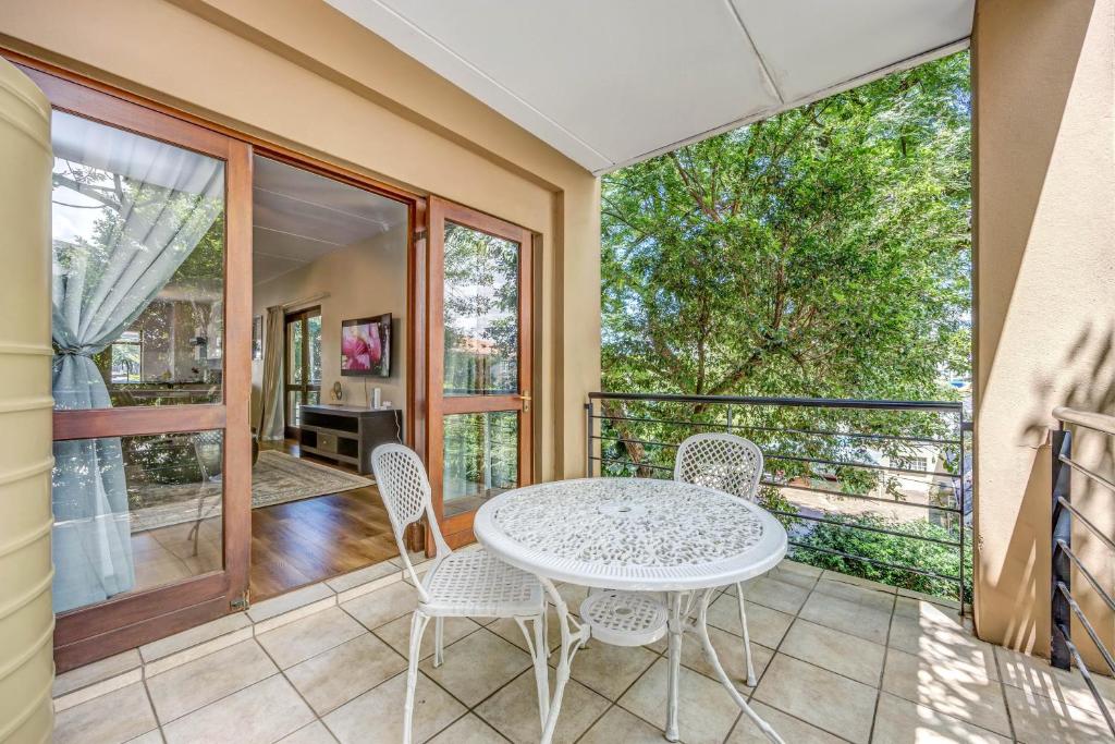 a room with a table and chairs on a balcony at Tashy Luxury 2 bedroomed apartment in Johannesburg