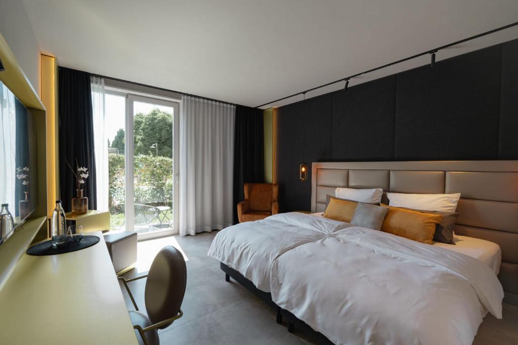 ein Schlafzimmer mit einem großen weißen Bett und einem Schreibtisch in der Unterkunft Scheck Hotel in München