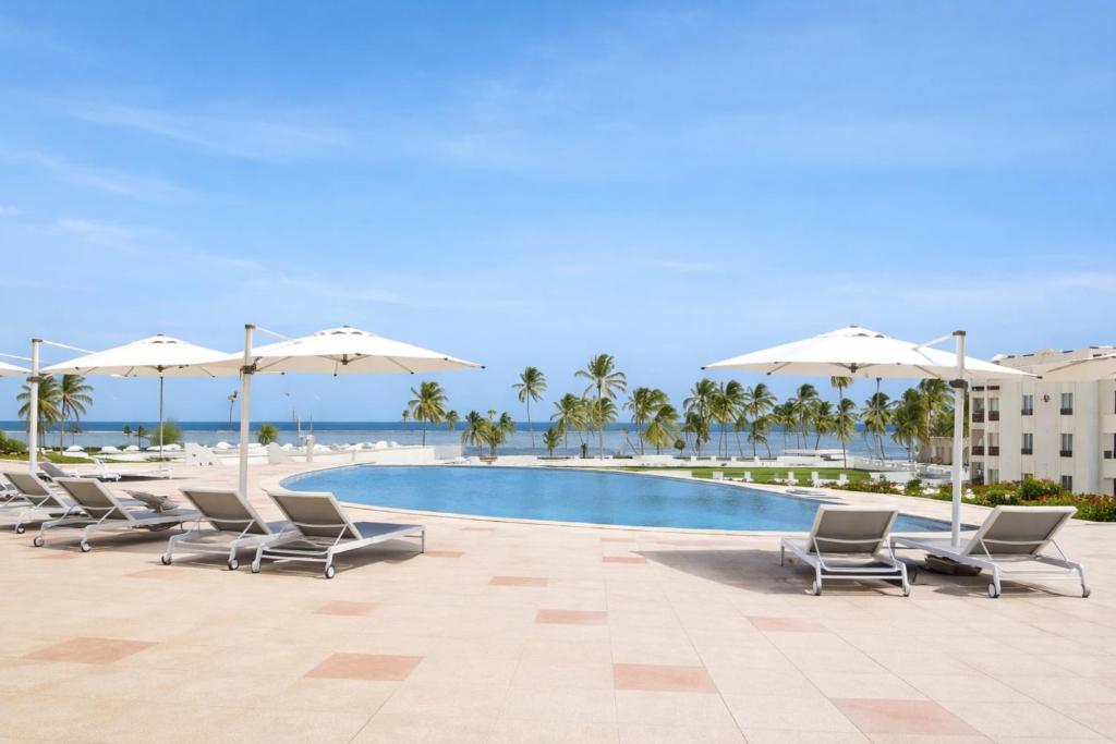 a group of chairs and umbrellas next to a pool at Diamonds Bijoux in Bwejuu