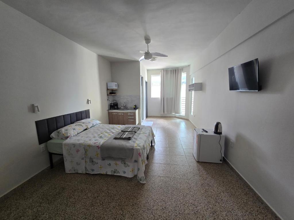 a bedroom with a bed and a flat screen tv at Ideal Center in Nova Serrana