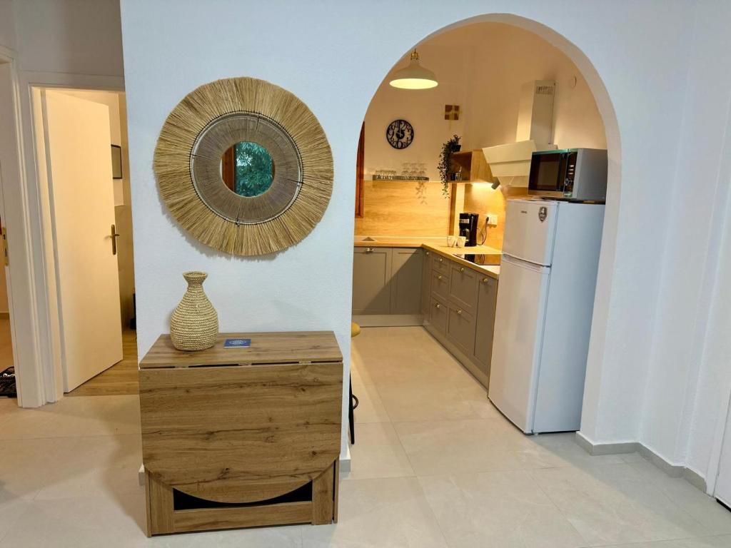 a kitchen with a refrigerator and a table and a mirror at NIVAS Apartment Pefkochori in Pefkochori