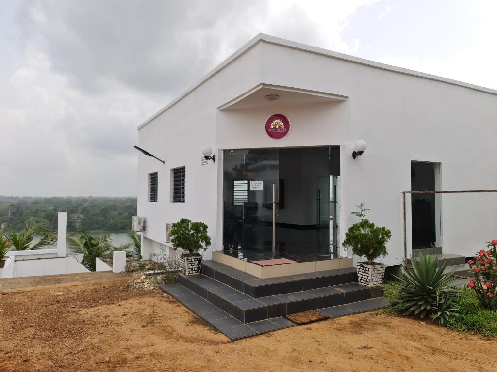 a white building with stairs in front of it at ADM HOTEL Grand-Lahou in Grand-Lahou