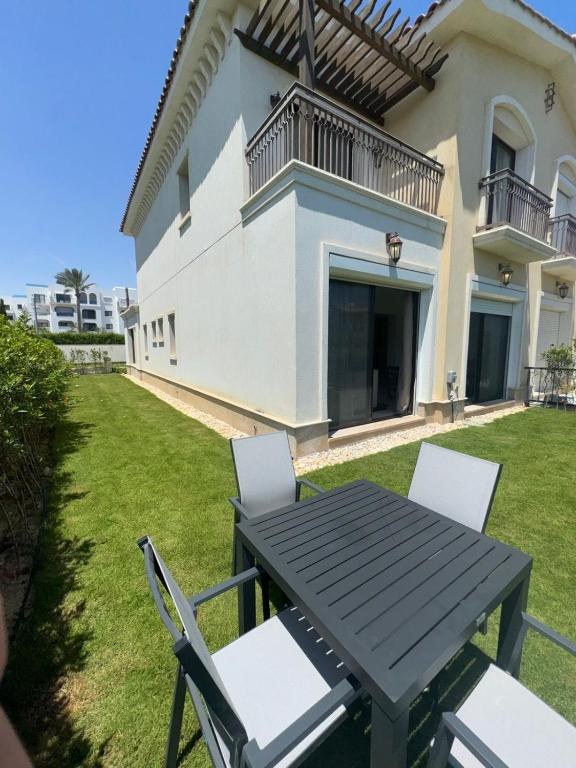 a black table and chairs in front of a house at Marassi villa in El Alamein