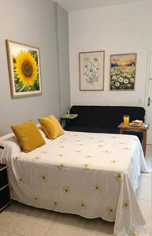 a bedroom with a bed with yellow pillows on it at Studio Catete Flamengo in Rio de Janeiro