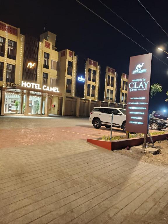 a white truck parked in a parking lot in front of a hotel at Hotel Camel managed by CLAY in Mundra