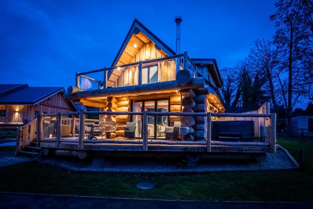 a tree house with a wrap around deck at night at The Lookout in Ilkley