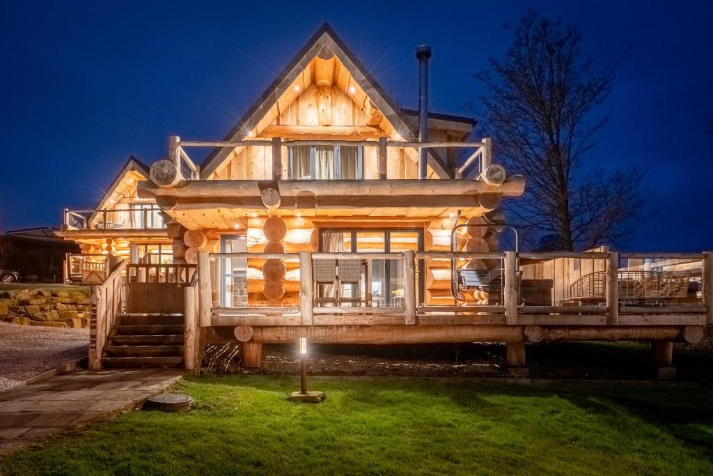 a large wooden house with a light lit up at Apres Ski in Ilkley
