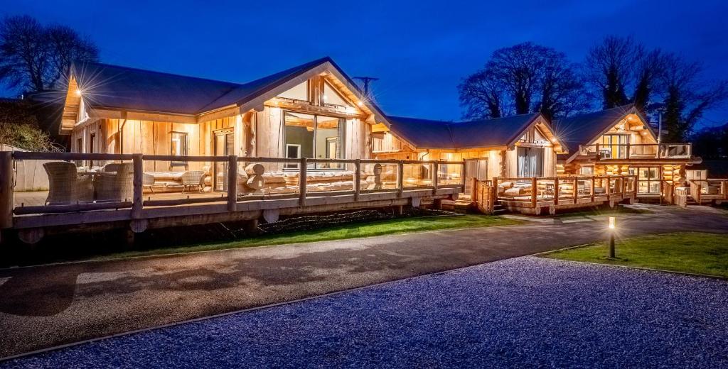 a large wooden house with a porch at night at The Farmhouse in Ilkley