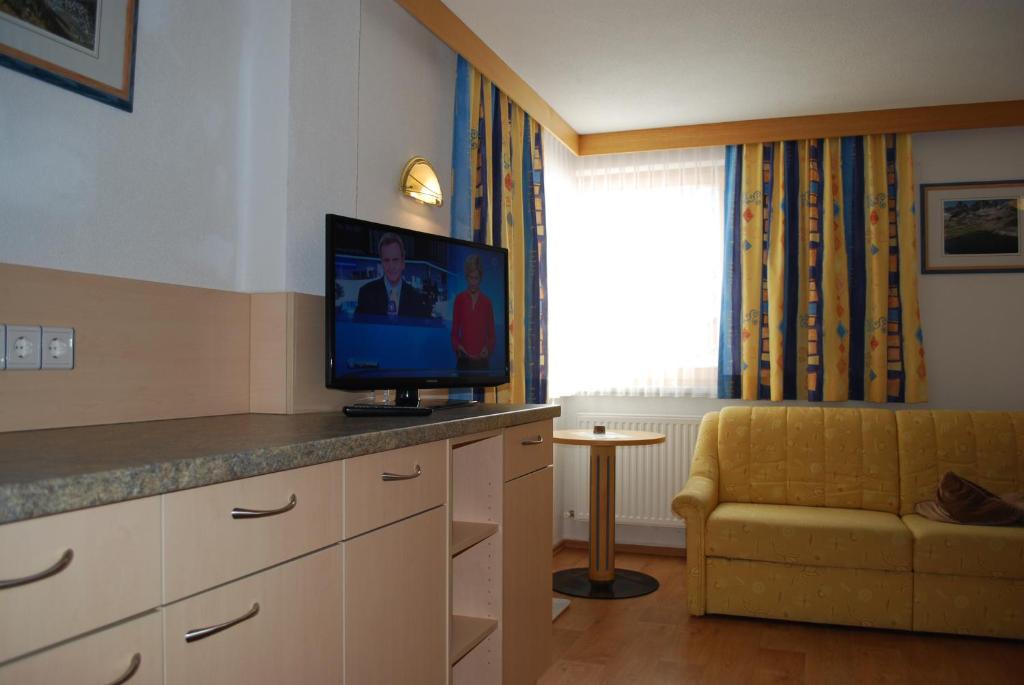 a room with a television on a counter with a couch at Chasa Monthani in Ischgl