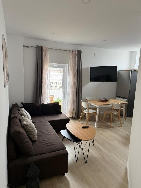 a living room with a couch and a table at Independent Apartment At Villa Noelia Benalmádena With Private Pool, Garden & Parking in Benalmádena