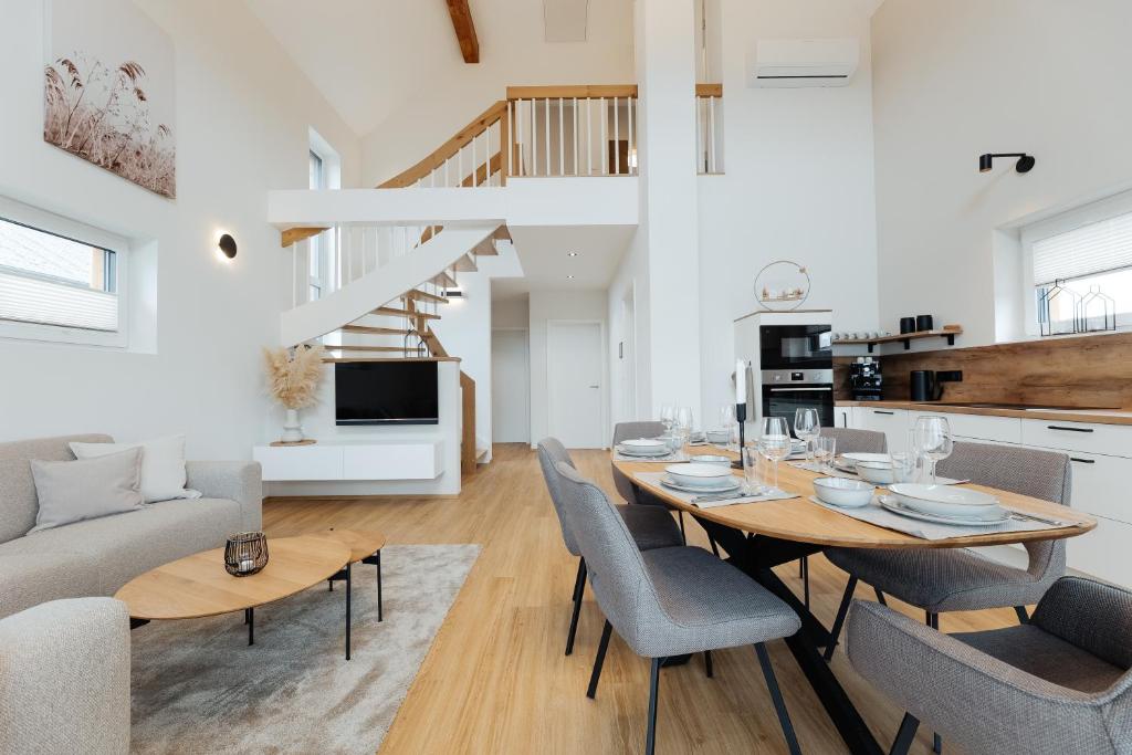 a dining room and living room with a table and chairs at Ferienhaus HeimatLay in Mörsdorf