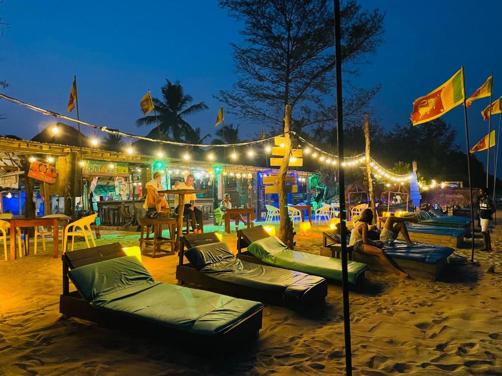 a group of people sitting on bean bags on the beach at night at Beach Lovers Tiny House in Nilaveli